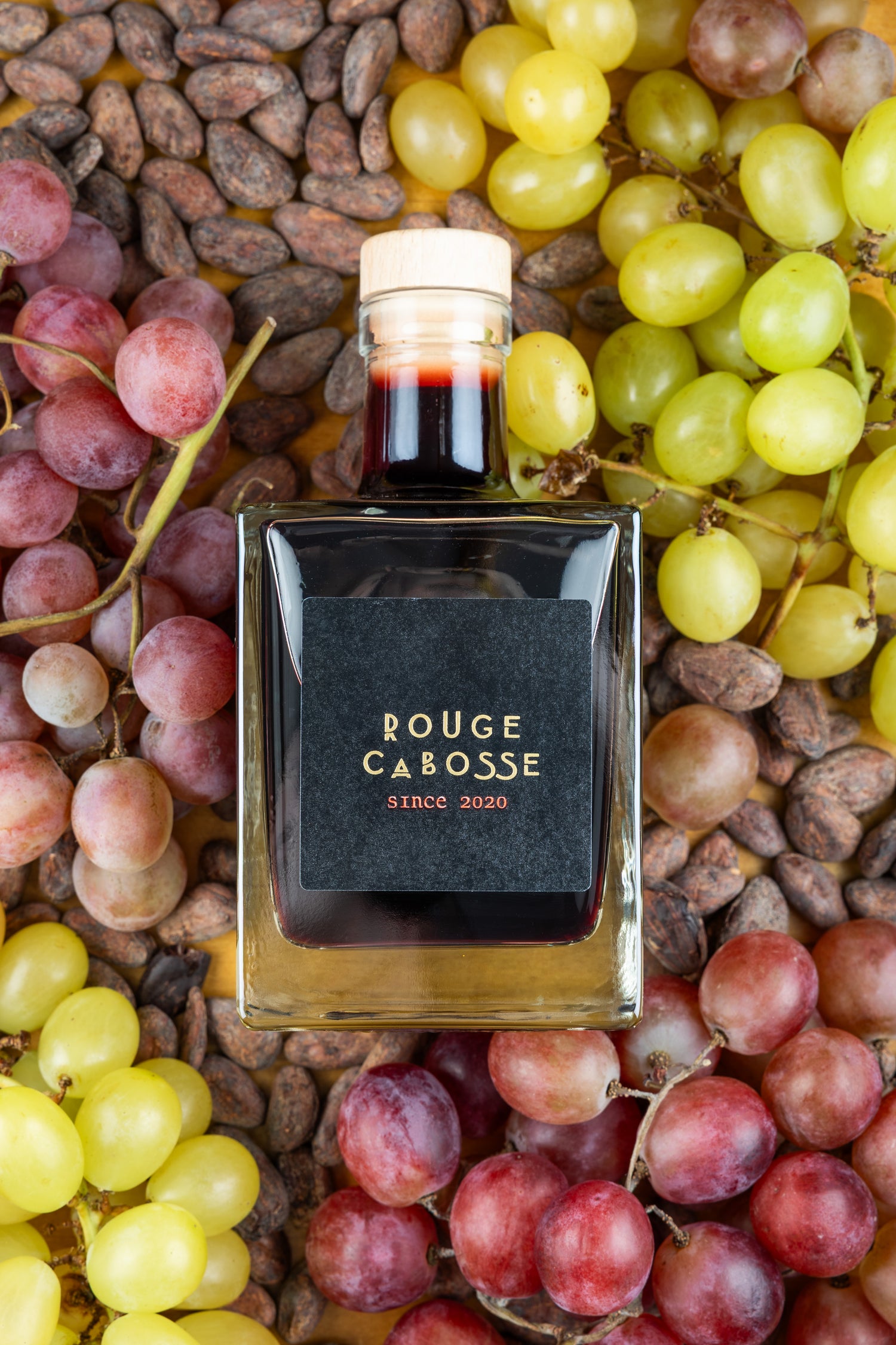photo d ela bouteille cubique rouge cabosse sur des raisins et des cabosse de cacao 