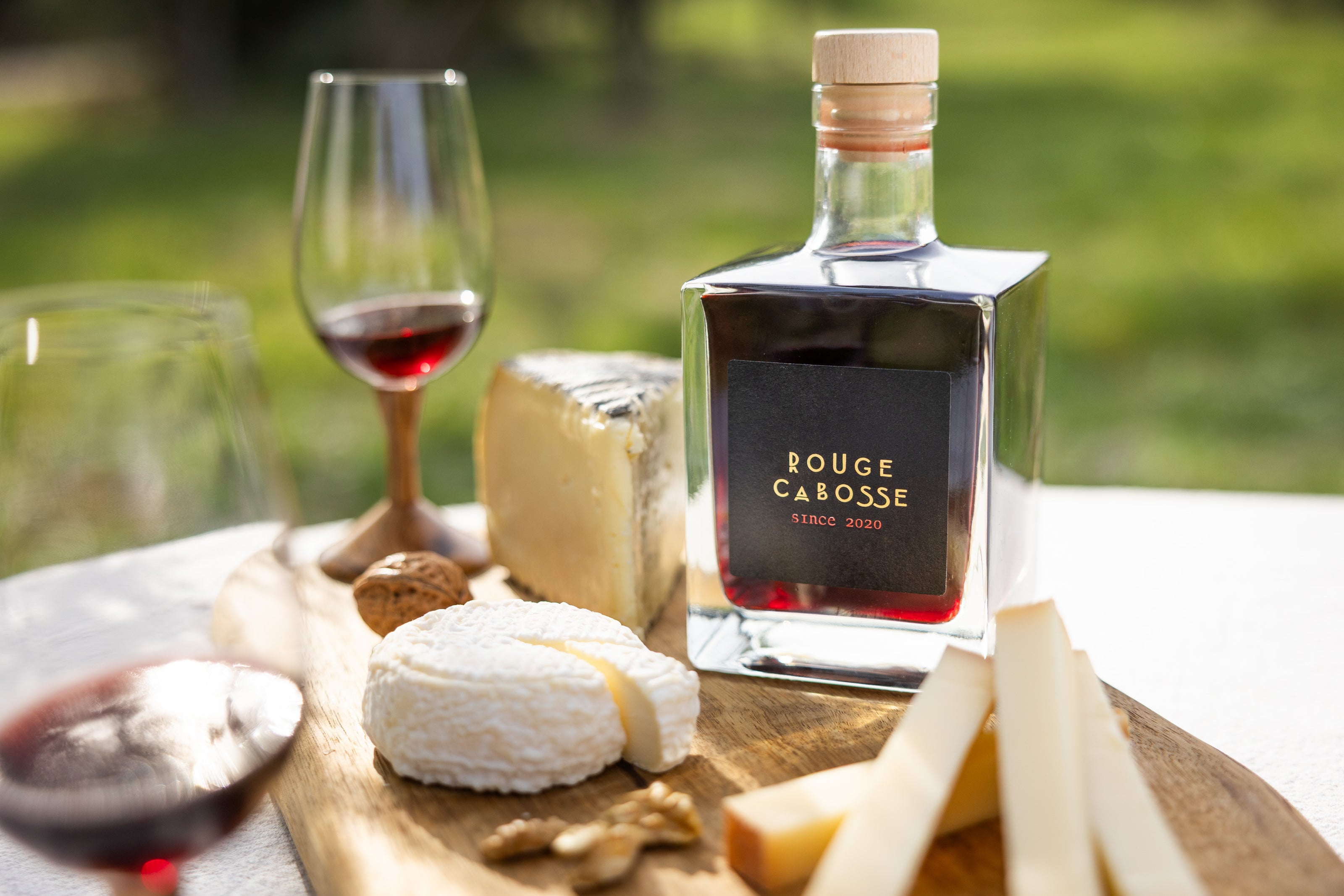 bouteille rouge cabosse accompagné de son plateau de fromage et de son verre à vin 